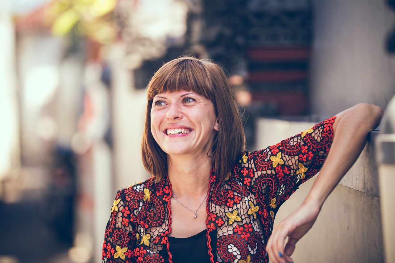 Photographie d'une femme adulte qui sourit, en montrant ses dents.